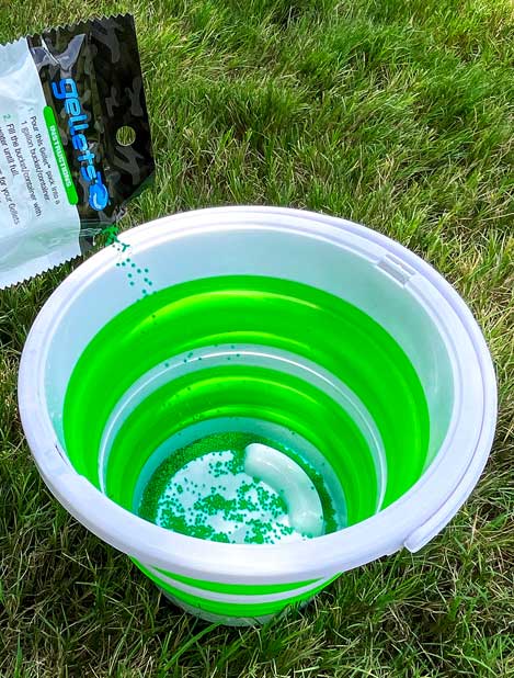 Bucket with soaking gel beads on grass